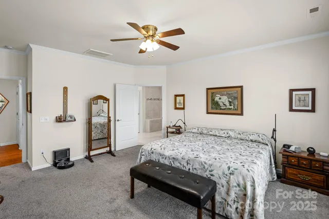 a bedroom with a bed a couch and a chandelier