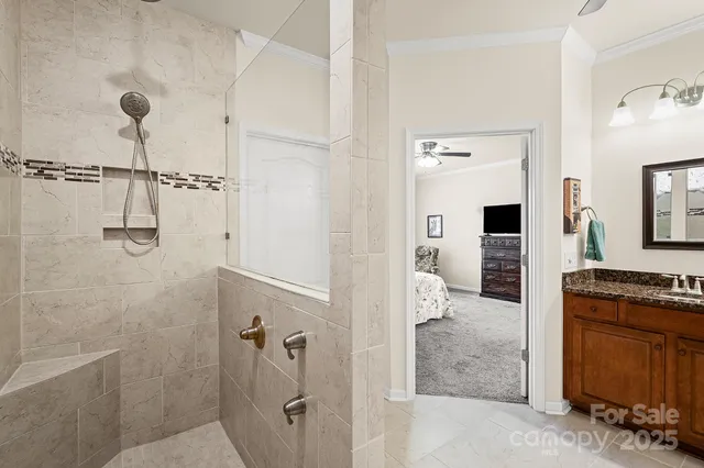 a bathroom with a granite countertop sink a mirror and shower