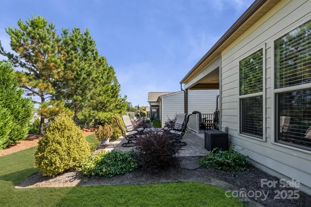 a view of backyard with plants and outdoor seating