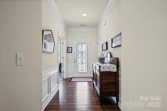 a hallway with wooden floor fireplace and windows