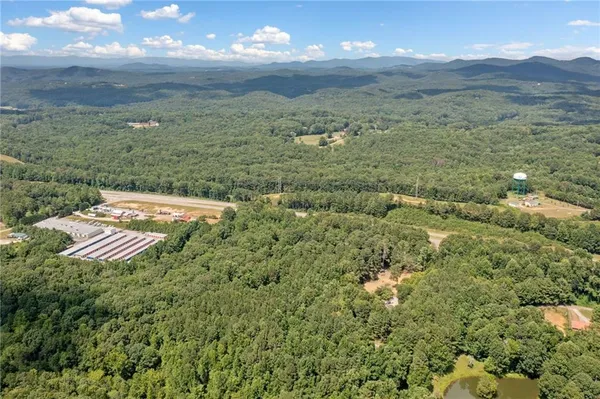 an aerial view of house with yard and mountain view in back