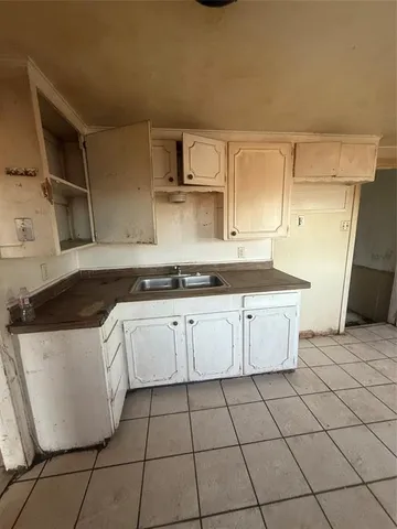 a kitchen with granite countertop a sink a stove and cabinets