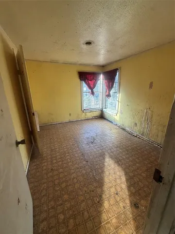 a view of empty room with floor to ceiling window and fireplace