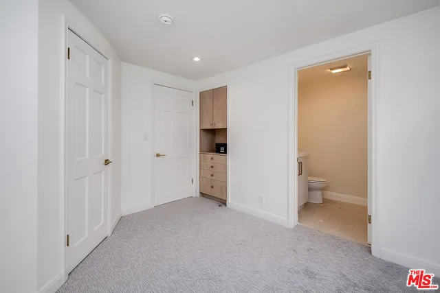 a view of a livingroom with wooden floor and a bathroom