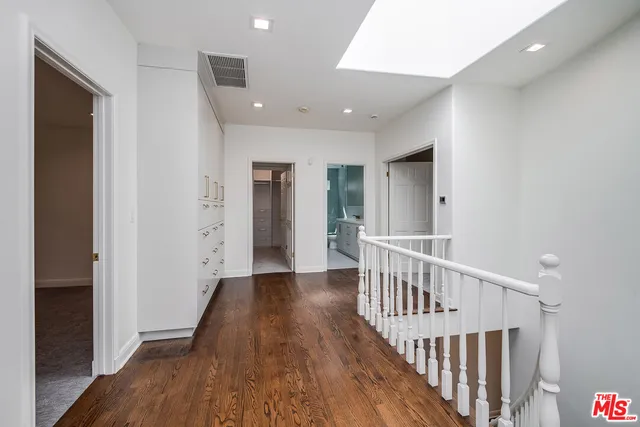 a view of a hallway with wooden floor and entryway