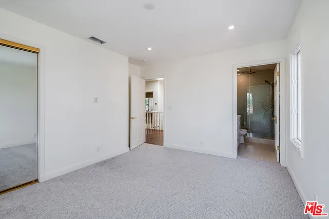 an empty room with closet and a bathroom