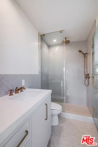 a bathroom with a sink a toilet and shower