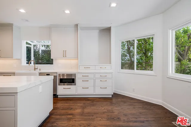 a kitchen with a stove window and cabinets