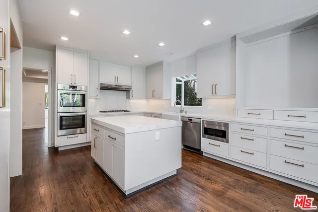 a kitchen with stainless steel appliances white cabinets and a refrigerator