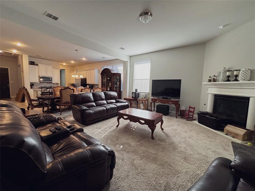 556 England Street Fate, TX 75189 - Photo 11 of 14 a living room with furniture a flat screen tv and a fireplace