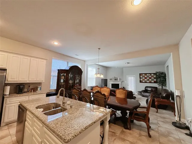 a kitchen with a sink a stove and chairs