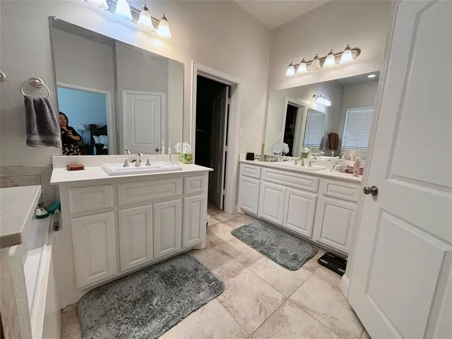 a spacious bathroom with a double vanity sink mirror and toilet