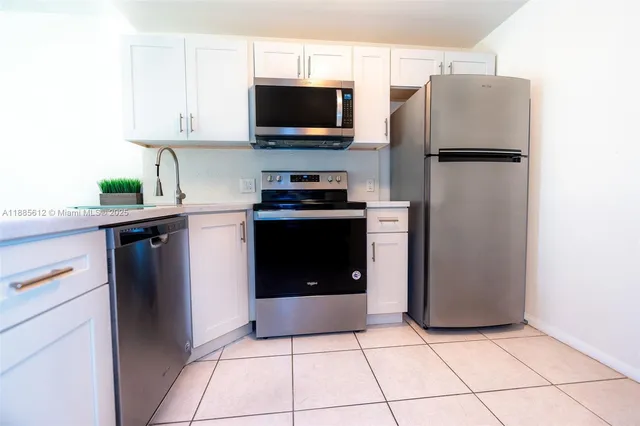 a kitchen with stainless steel appliances granite countertop a refrigerator and a stove