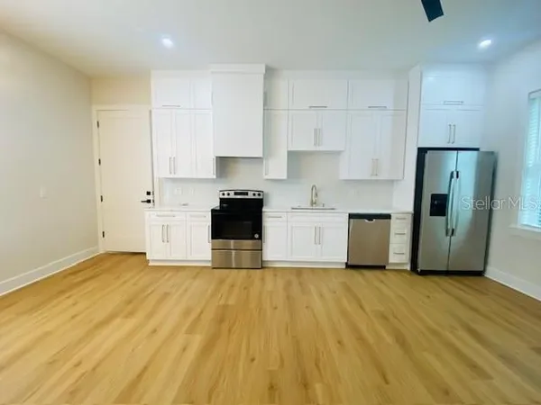 a view of kitchen with stainless steel appliances refrigerator stove microwave and cabinets