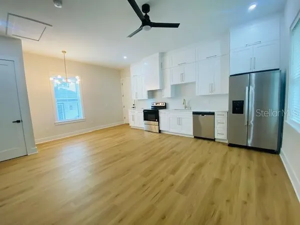 a view of empty room with wooden floor and fan
