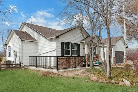 a view of a house with a yard and wooden fence