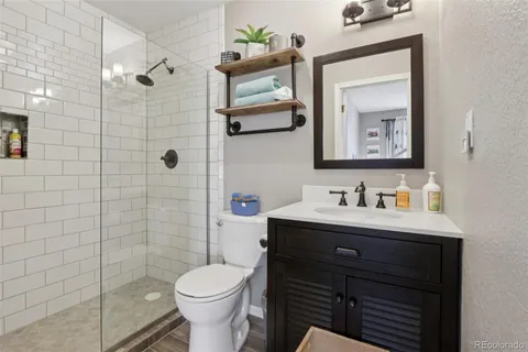 a bathroom with a toilet sink vanity and mirror