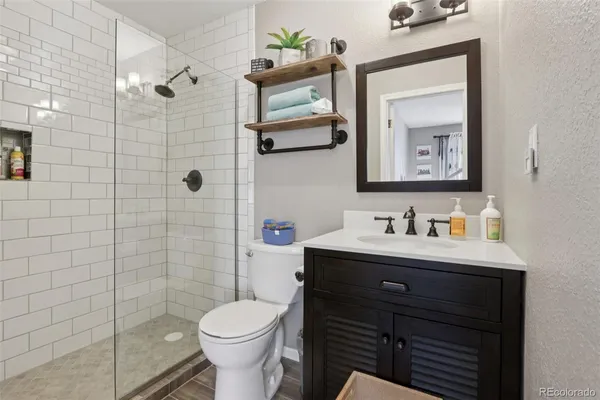 a bathroom with a toilet sink vanity and mirror