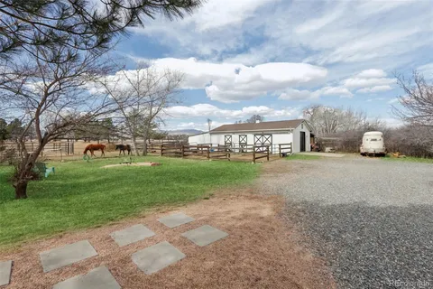 a view of a house with a big yard and large trees