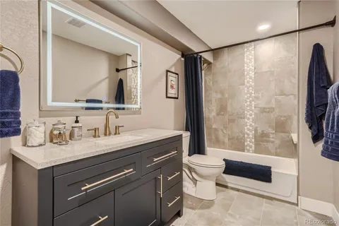 a bathroom with a granite countertop sink toilet and shower