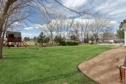 a view of a wooden deck and a backyard