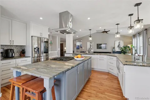 a kitchen with stainless steel appliances granite countertop wooden cabinets a stove top oven a sink and dishwasher