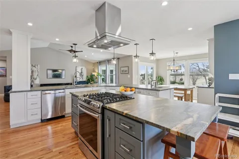 a kitchen with stainless steel appliances granite countertop a stove and a wooden floors