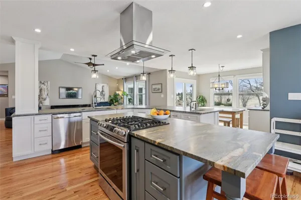 a kitchen with stainless steel appliances granite countertop a stove and a wooden floors