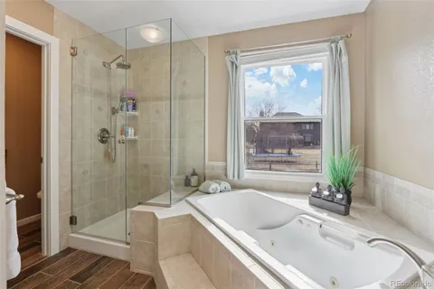 a bathroom with a granite countertop tub a sink and a large mirror