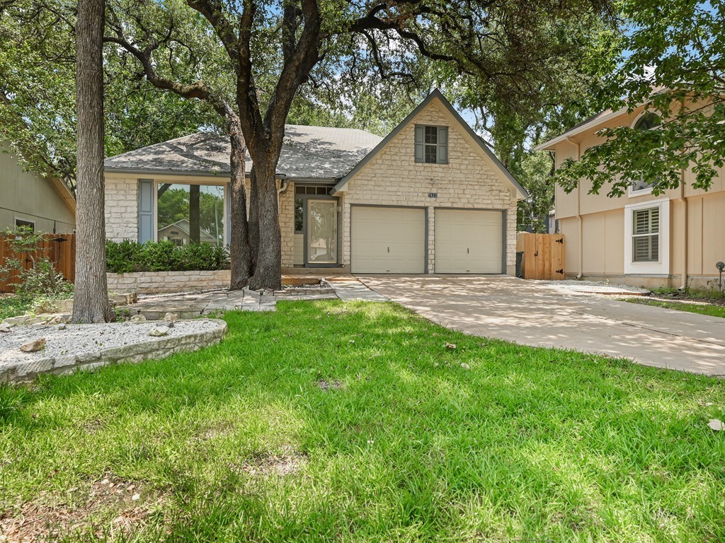 a front view of a house with yard and green space