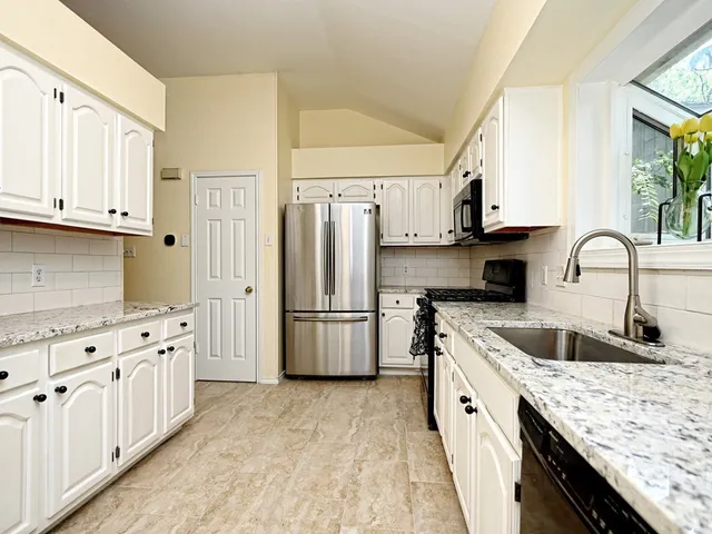 a kitchen with white cabinets and stainless steel appliances