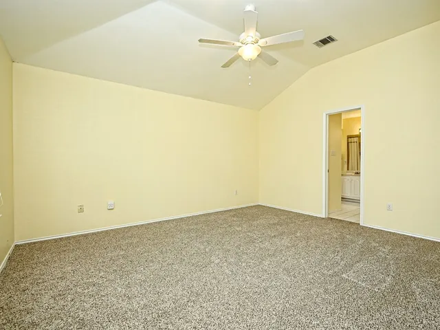 an empty room with a ceiling fan and a window