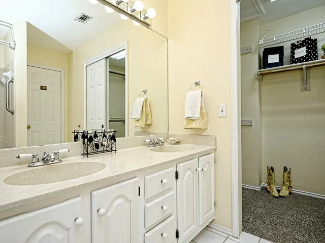 a bathroom with double sink and a mirror