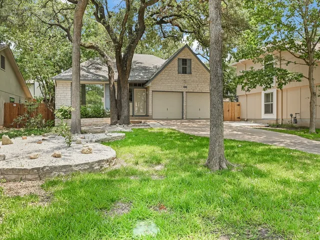 a front view of a house with a yard and trees