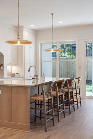 a large white kitchen with a large window and stainless steel appliances