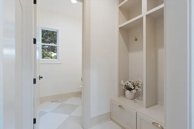 a living room with furniture kitchen view and a chandelier