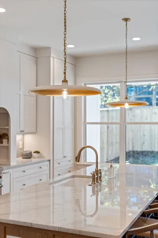 a kitchen with a stove a window and chairs