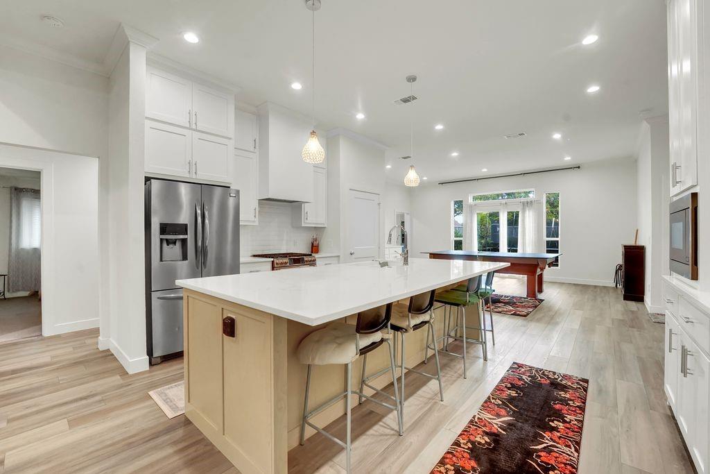 4035 Cedarview Road Dallas, TX 75287 - Photo 10 of 31 a large kitchen with stainless steel appliances kitchen island a stove a refrigerator a oven and a sink with large countertops