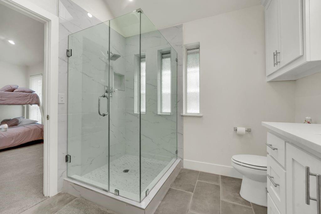 4035 Cedarview Road Dallas, TX 75287 - Photo 13 of 31 a bathroom with a shower a toilet and a sink