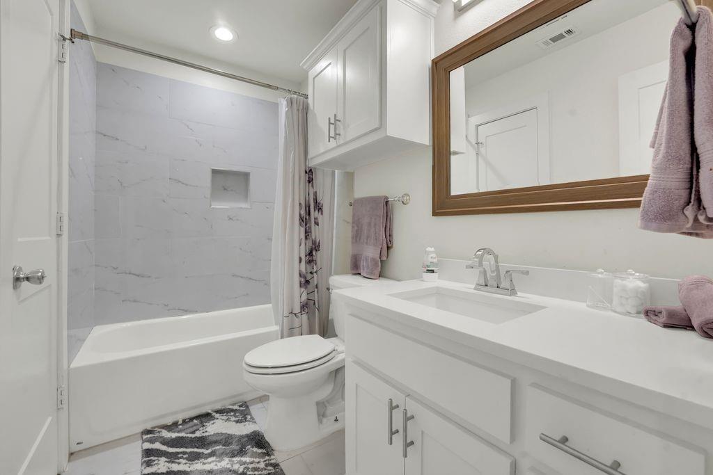4035 Cedarview Road Dallas, TX 75287 - Photo 16 of 31 a bathroom with a bathtub shower sink vanity and toilet