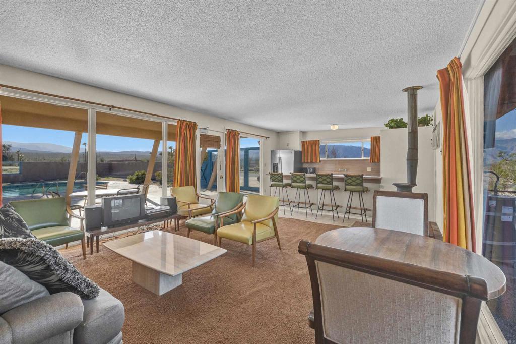 4235 Fletcher Road Borrego Springs, CA 92004 - Photo 5 of 31 a living room with couches a coffee table and a large window with outer view