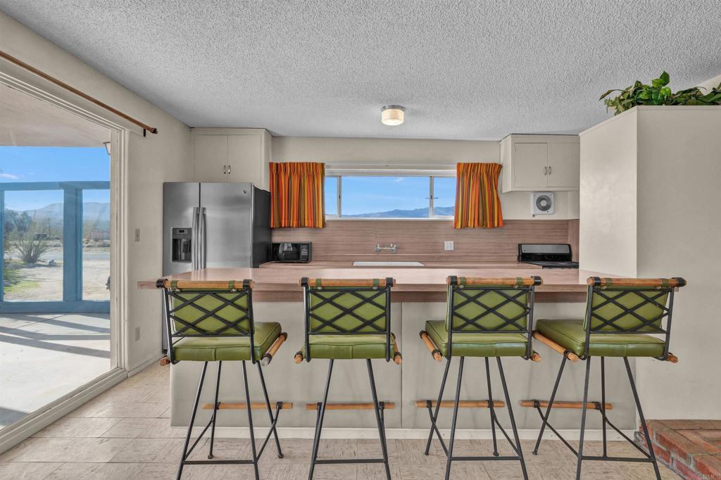 4235 Fletcher Road Borrego Springs, CA 92004 - Photo 8 of 31 a view of kitchen with stainless steel appliances kitchen island granite countertop dining room and chairs
