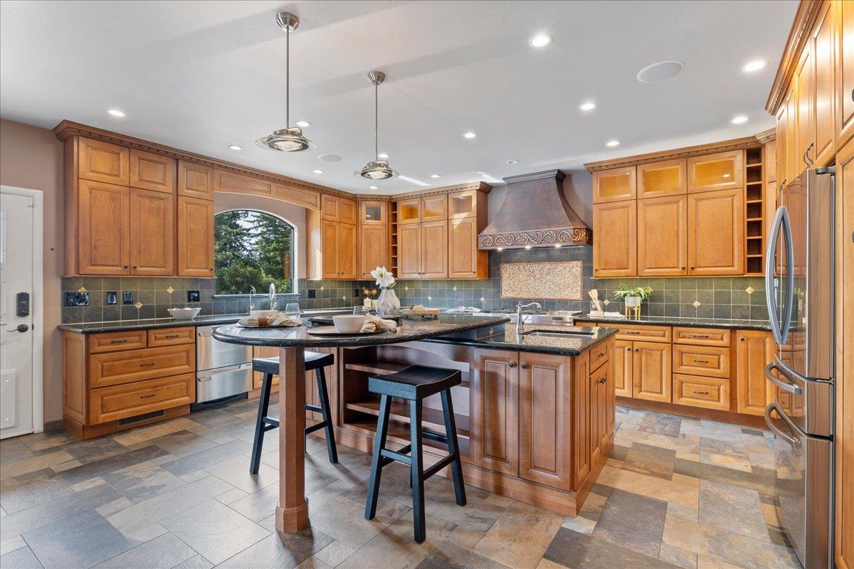 23435 Summit Road Los Gatos, CA 95033 - Photo 23 of 86 a kitchen with stainless steel appliances granite countertop wooden cabinets a stove a sink a dining table and chairs