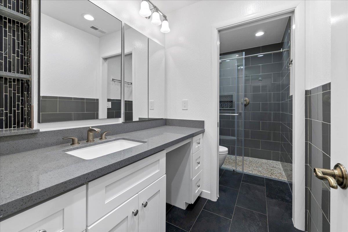 23435 Summit Road Los Gatos, CA 95033 - Photo 48 of 86 a bathroom with a granite countertop sink a toilet and shower