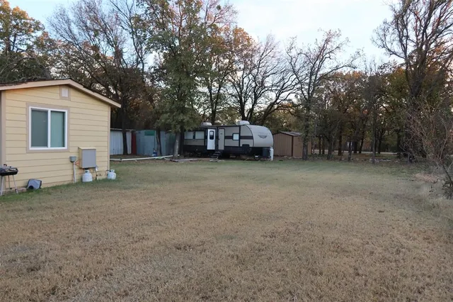 a view of a house with a large tree and a yard