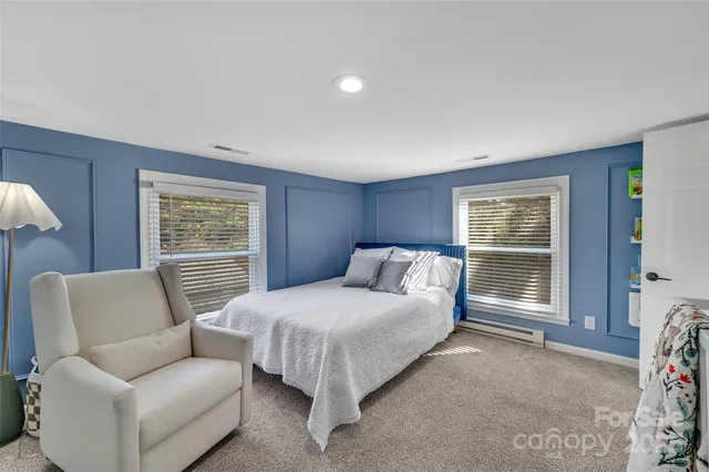 a bedroom with a bed couch and a window