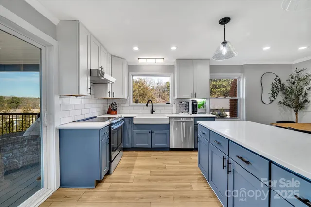 a large kitchen with kitchen island a sink stainless steel appliances and cabinets