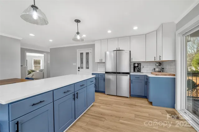 a kitchen with kitchen island granite countertop appliances cabinets a sink and a counter top space