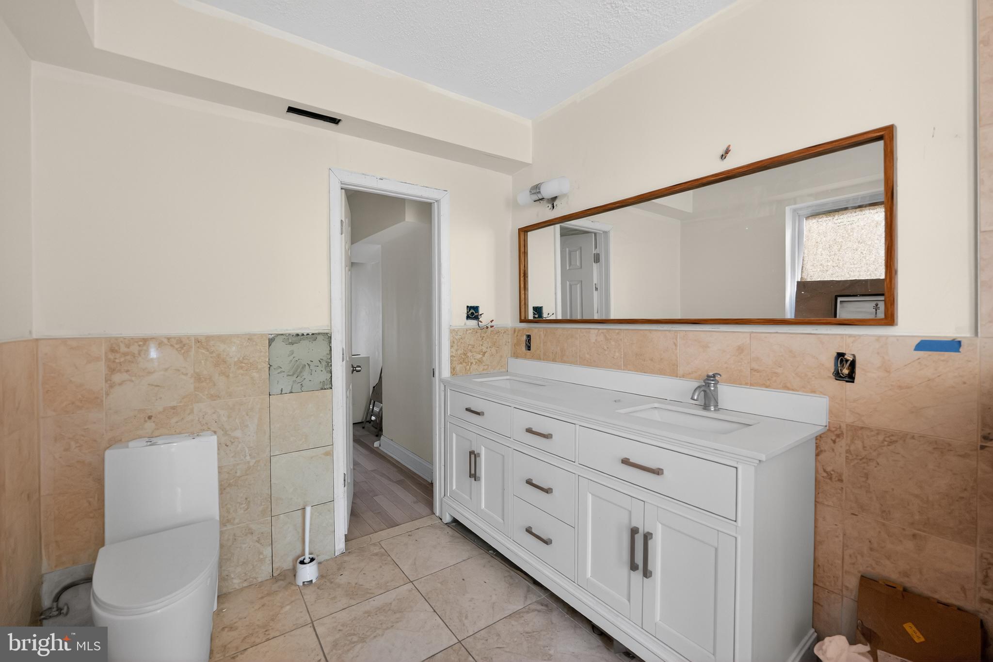 714 Portland Street Baltimore, MD 21230 - Photo 11 of 18 a spacious bathroom with a granite countertop sink mirror and toilet