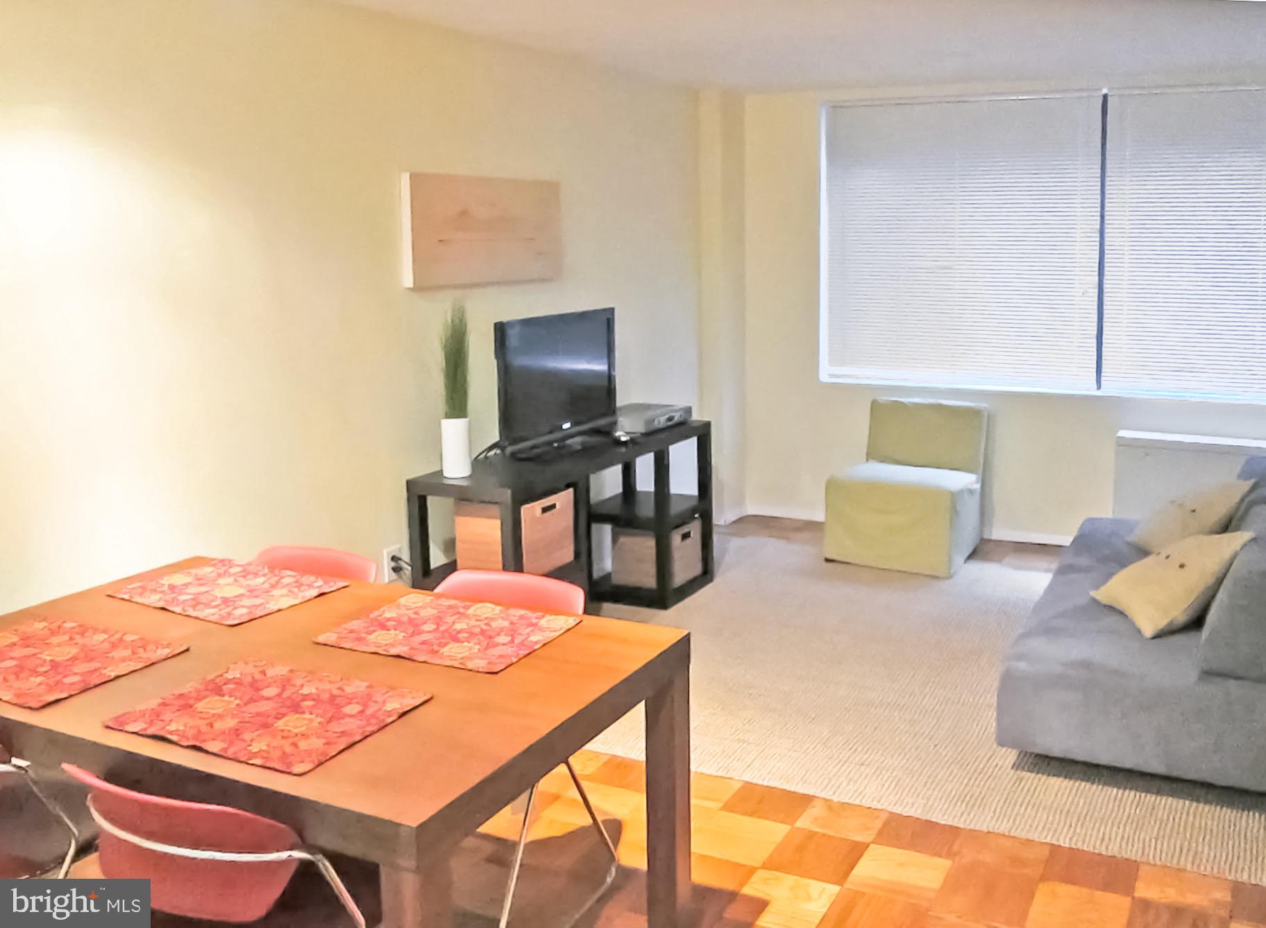 2030 F Street Northwest, Unit 211 Washington, DC 20006 - Photo 6 of 10 a bedroom with a bed and a flat screen tv